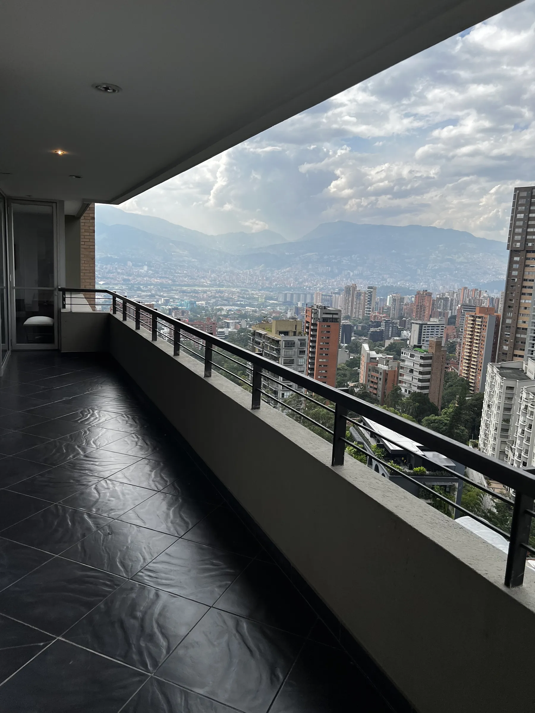 The terrace looking west across El Poblado towards the cordillera, cloud breaking over the ridgeline